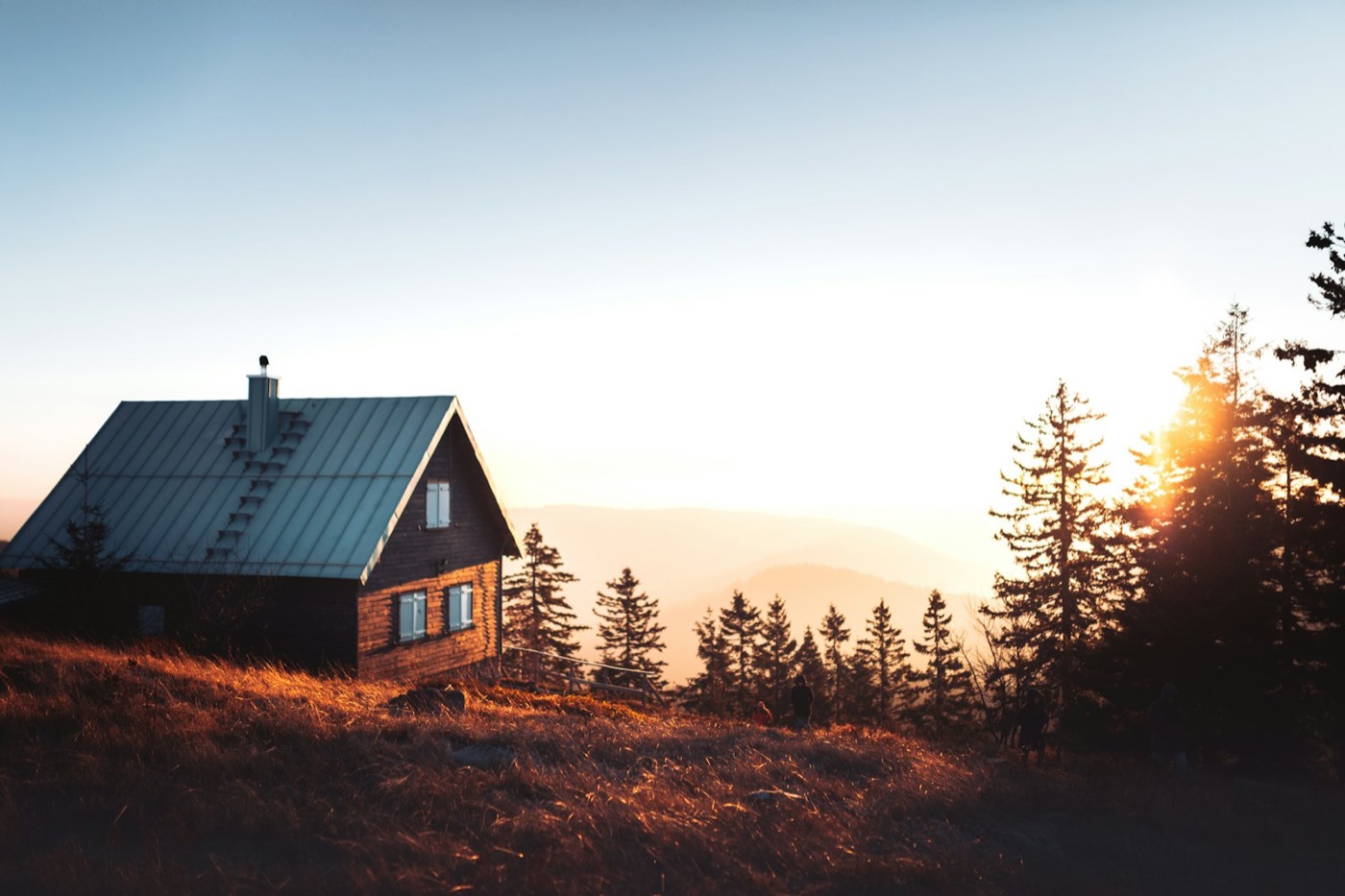 夕暮れの森に建つ小屋